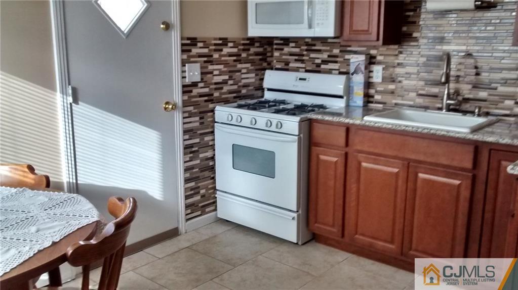 5 Ashley Road Edison, NJ 08817 - Photo 10 of 25 a kitchen with granite countertop wooden cabinets and white appliances