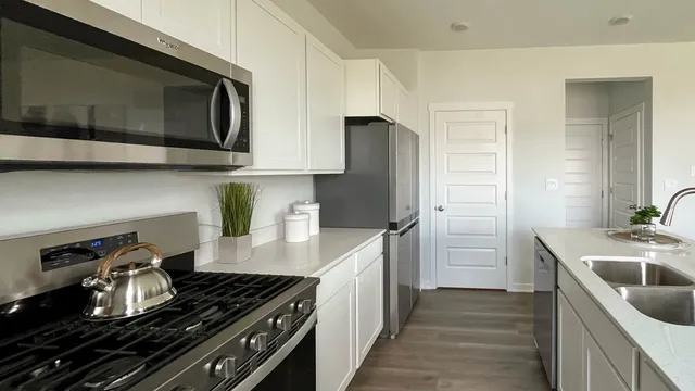 a kitchen with stainless steel appliances granite countertop a sink stove and refrigerator