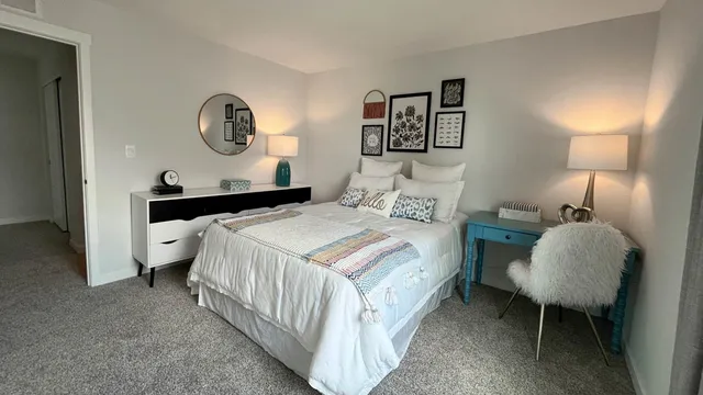 a bedroom with a bed and painting on the wall