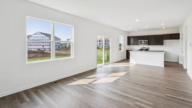 a view of kitchen with stainless steel appliances wooden floor and a refrigerator