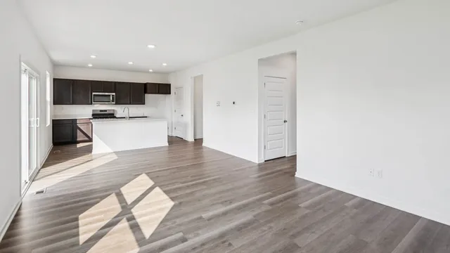 a view of a living room with wooden floor and a window