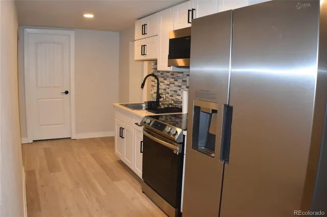a kitchen with stainless steel appliances a refrigerator a stove and a sink