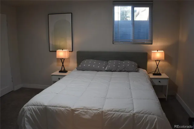 a bedroom with a bed and a lamp