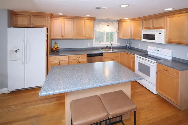 a kitchen with stainless steel appliances granite countertop a sink a stove top oven a counter space and cabinets