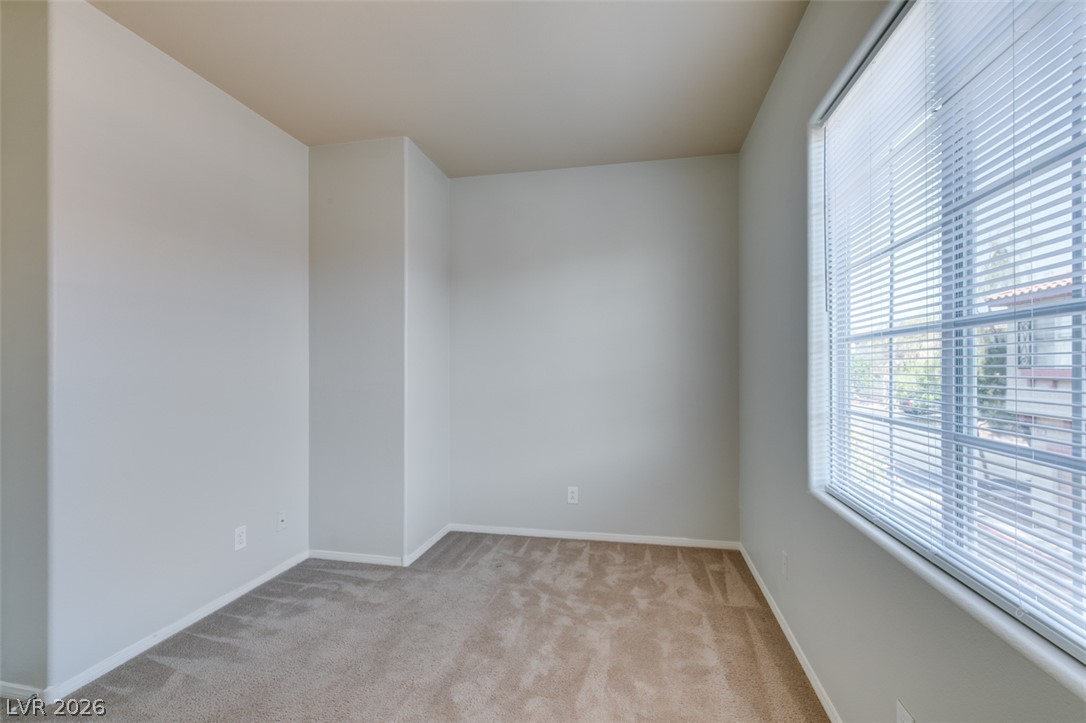 8937 Caledon Ridge Court Las Vegas, NV 89149 - Photo 30 of 43 A well-lit room offers fresh carpeting and a large window for ample natural light.