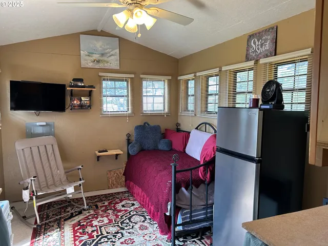 a living room with furniture a flat screen tv and large window