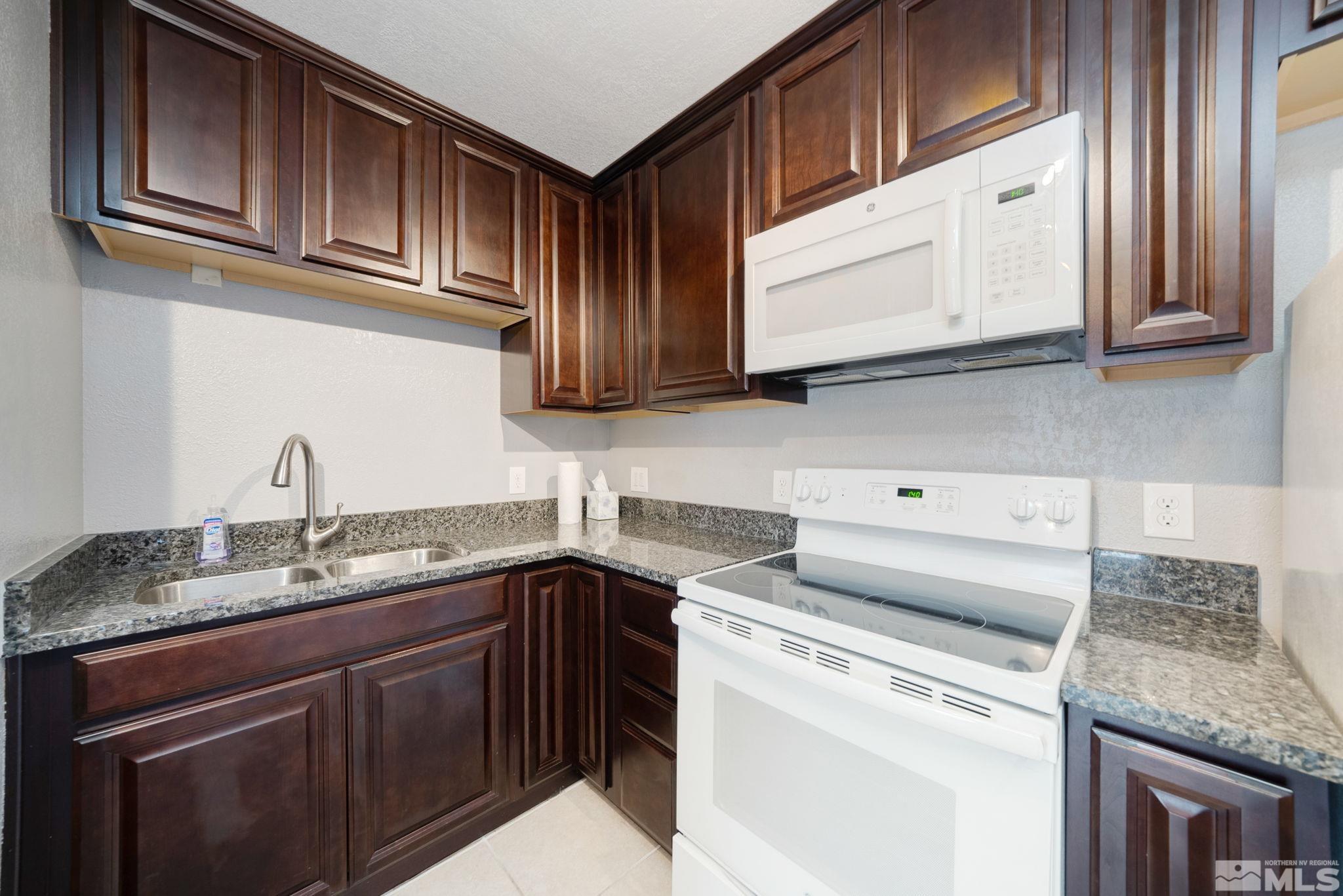 2450 Lymbery Street, Unit 227 Reno, NV 89509 - Photo 3 of 14 a kitchen with stainless steel appliances granite countertop a sink stove and cabinets