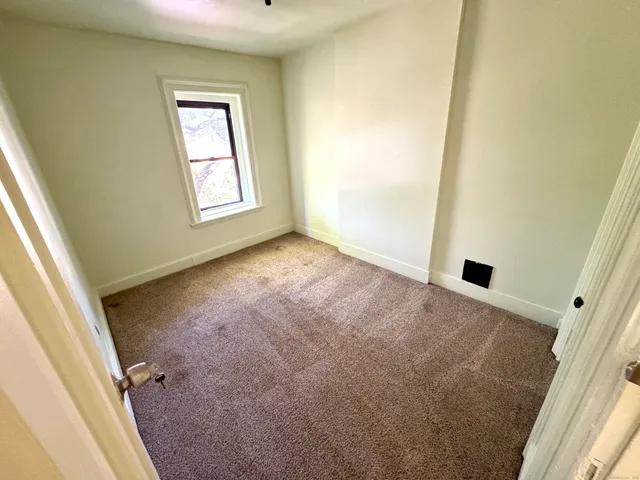 an empty room with windows and closet