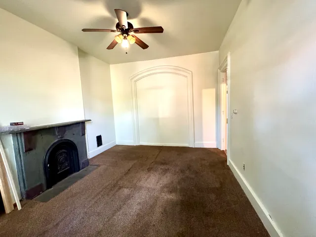 a view of empty room with fireplace and fan