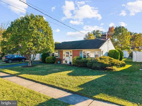 a view of a house with a big yard plants and large trees