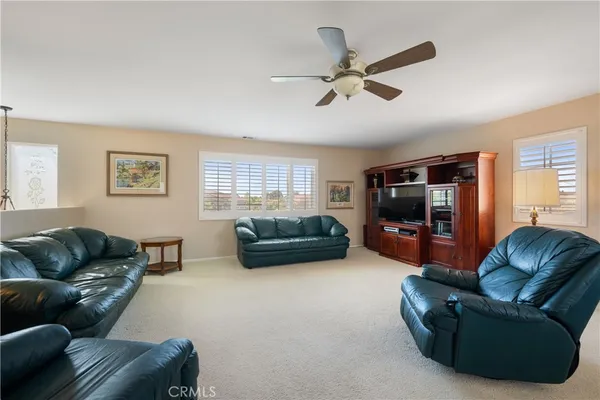 a living room with furniture ceiling fan and a window