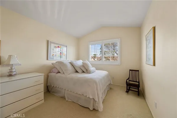 a bedroom with a bed and a lamp on dresser