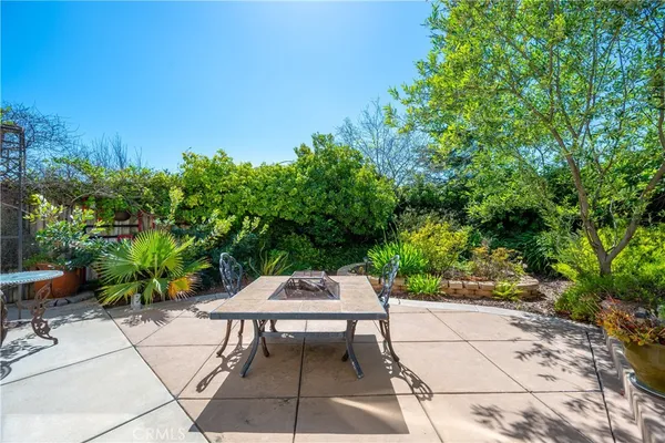 a patio with table and chairs and potted plants