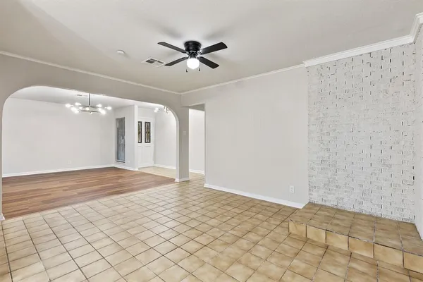 an empty room with windows and ceiling fan