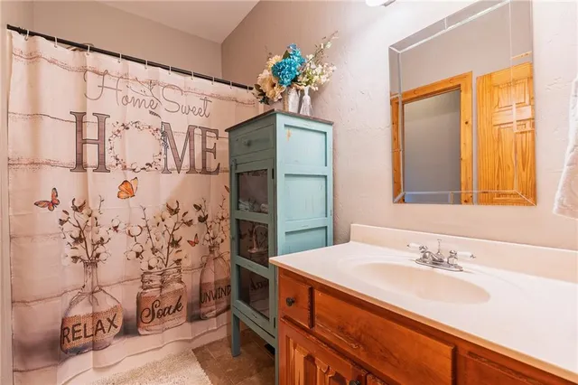 a bathroom with a granite countertop sink a vanity and a shower