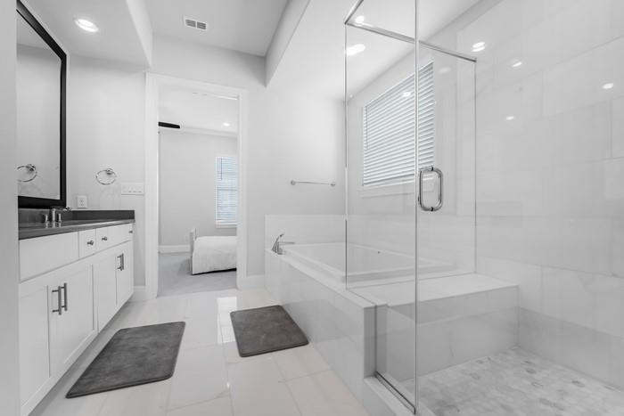 633 Dalton Lane Irving, TX 75039 - Photo 12 of 26 a bathroom with a tub shower vanity and a sink