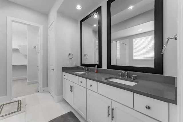 a bathroom with double sink and a mirror