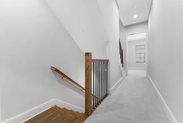 a view of a hallway with wooden floor and entryway