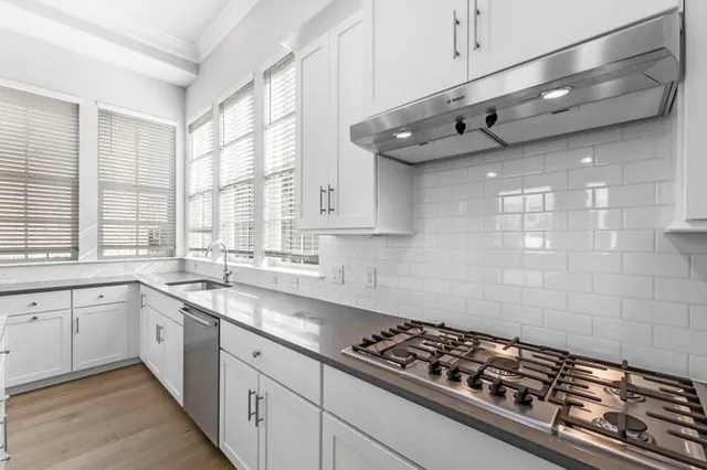 a kitchen with stainless steel appliances a sink a stove and cabinets