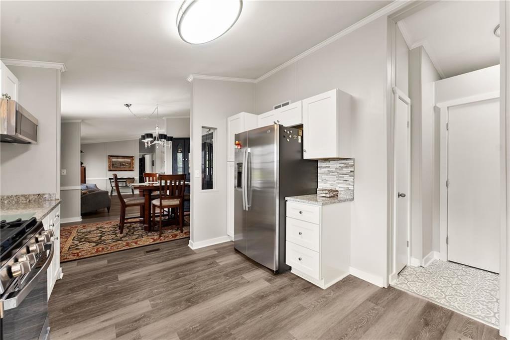 1689 Old State Road Pendergrass, GA 30567 - Photo 27 of 58 a kitchen with stainless steel appliances a refrigerator and wooden floor