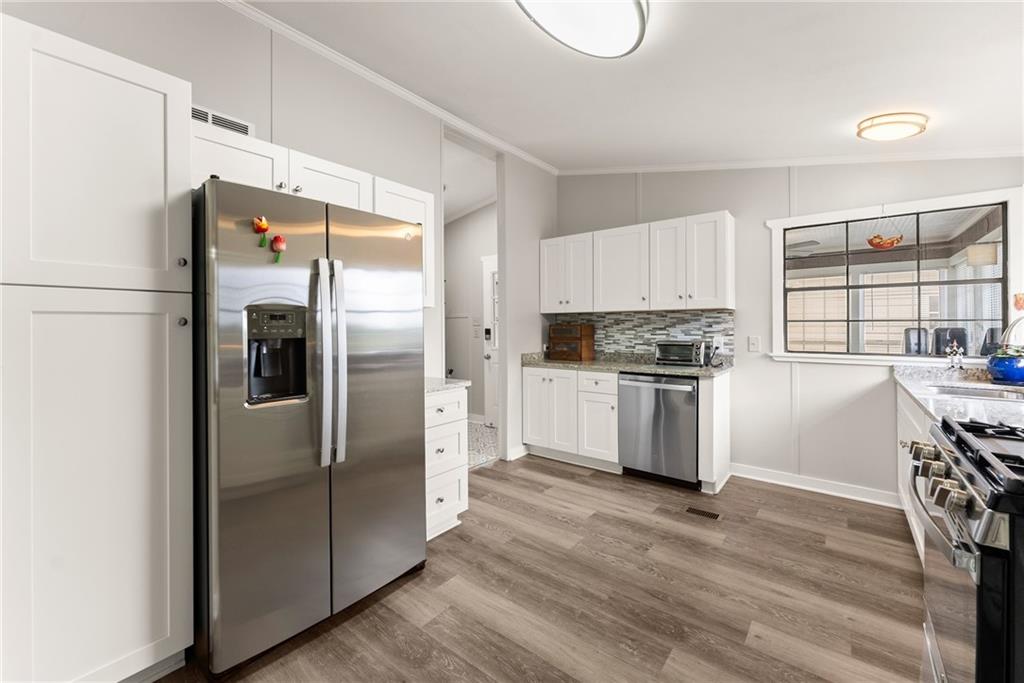 1689 Old State Road Pendergrass, GA 30567 - Photo 28 of 58 a kitchen with granite countertop a refrigerator and a stove top oven