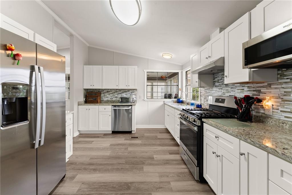 1689 Old State Road Pendergrass, GA 30567 - Photo 29 of 58 a large kitchen with cabinets stainless steel appliances and a counter space