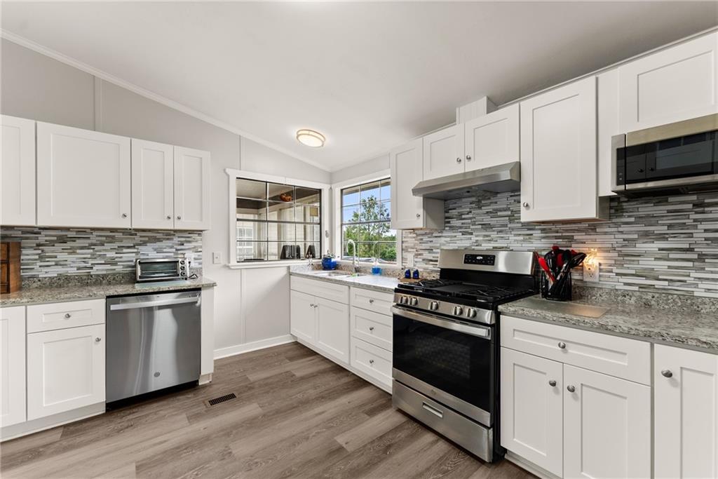 1689 Old State Road Pendergrass, GA 30567 - Photo 30 of 58 a kitchen with white cabinets and appliances