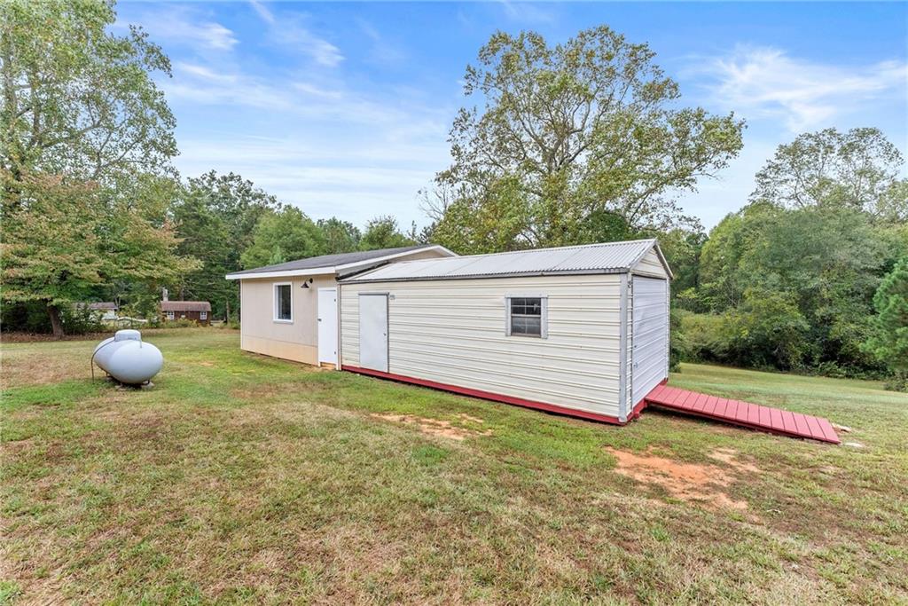 1689 Old State Road Pendergrass, GA 30567 - Photo 40 of 58 a view of a backyard with plants and a large tree