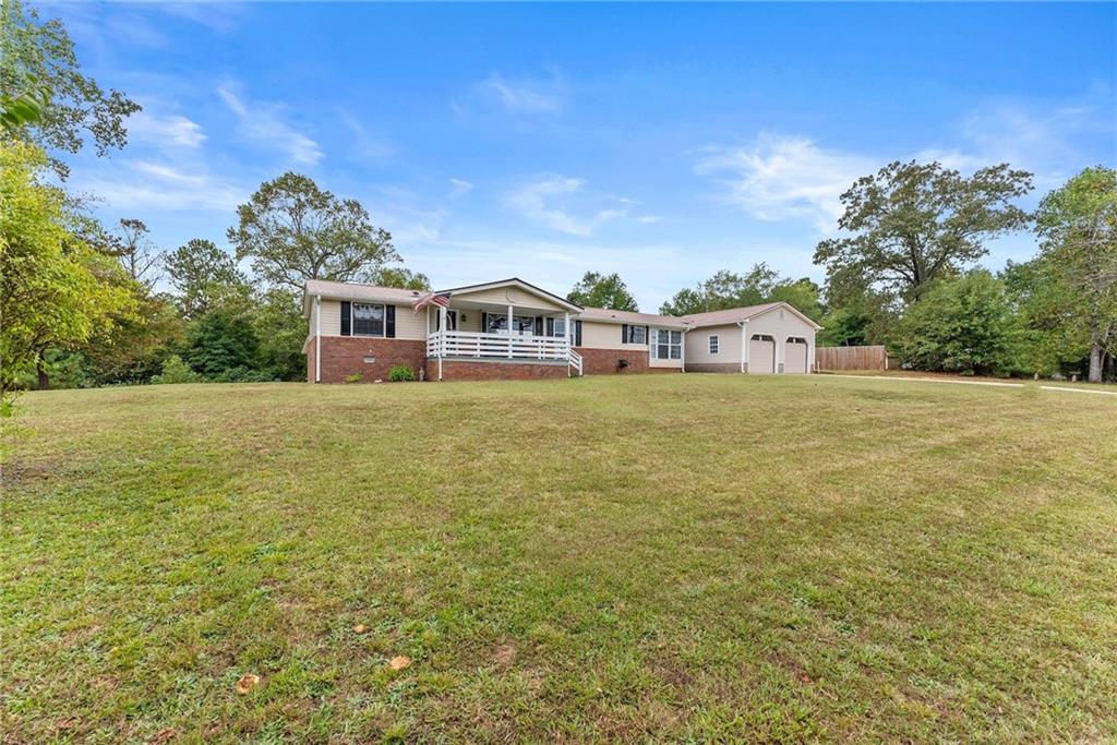 1689 Old State Road Pendergrass, GA 30567 - Photo 5 of 58 a view of a house with a big yard and large trees