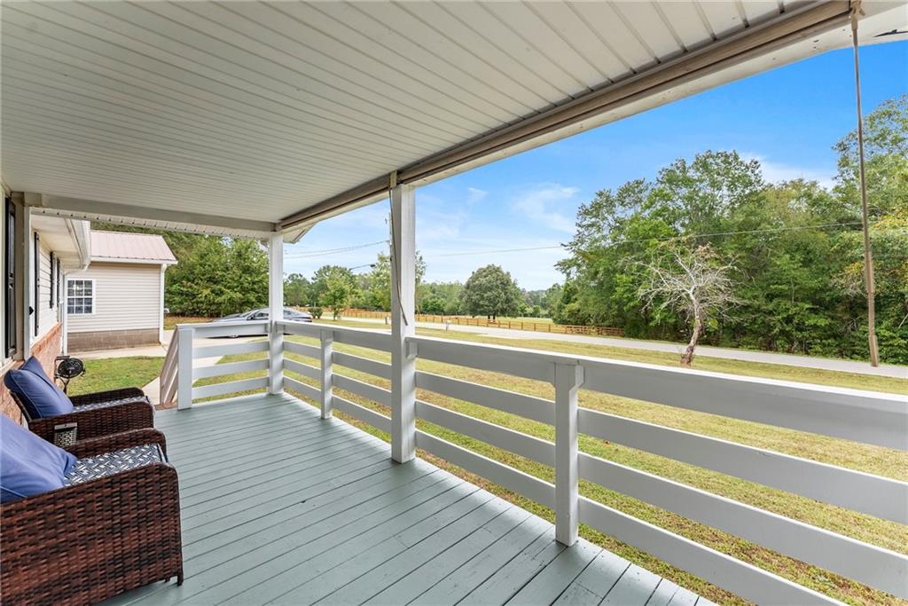 1689 Old State Road Pendergrass, GA 30567 - Photo 6 of 58 a view of a deck with wooden floor and fence next to a yard