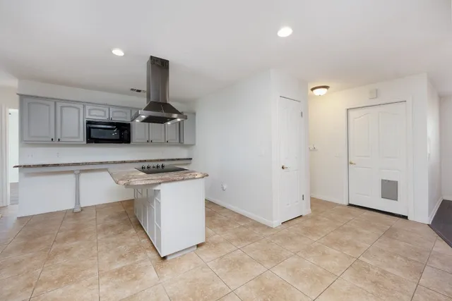 a kitchen with granite countertop a sink and a stove top oven