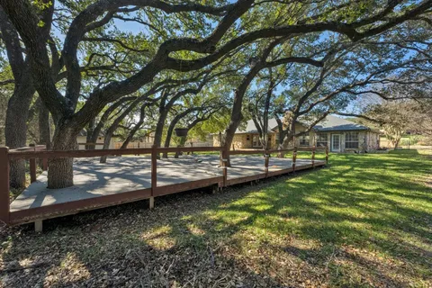 a view of yard with wooden deck and a large tree