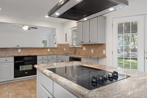 a kitchen with a sink a stove and cabinets