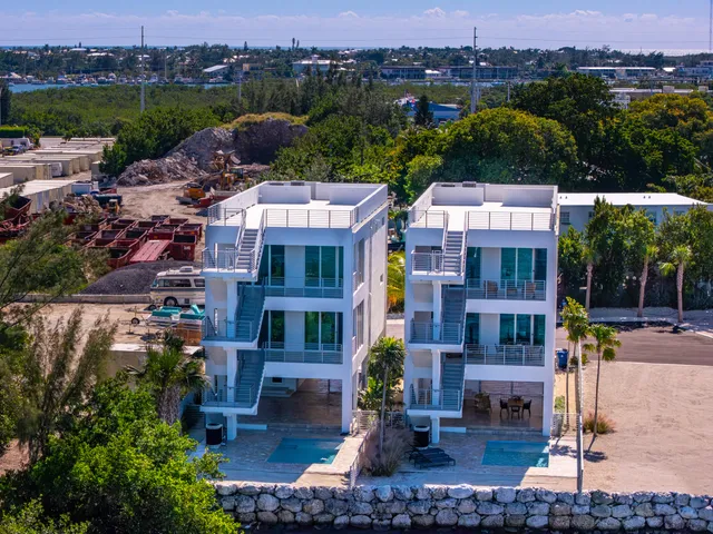 an aerial view of multiple houses with a yard