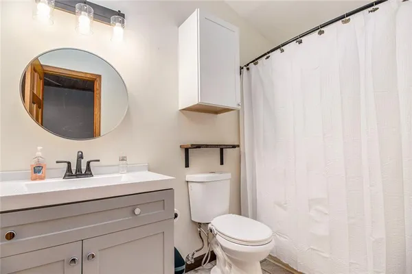 a bathroom with a toilet sink vanity and mirror