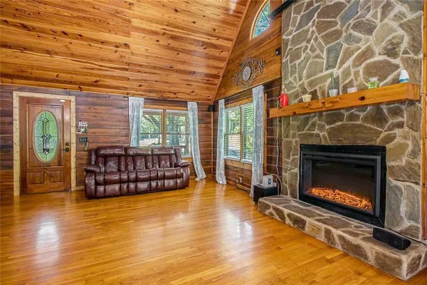 a living room with furniture a fireplace and wooden floor