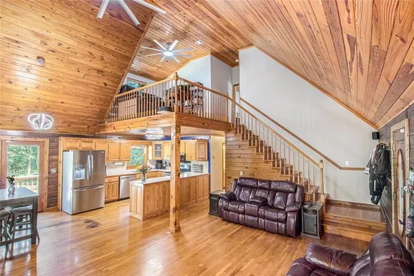 a view of a livingroom with wooden floor and furniture