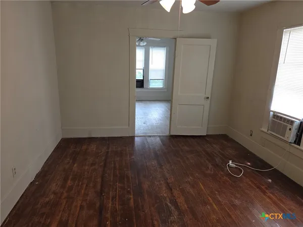 wooden floor in an empty room with a window