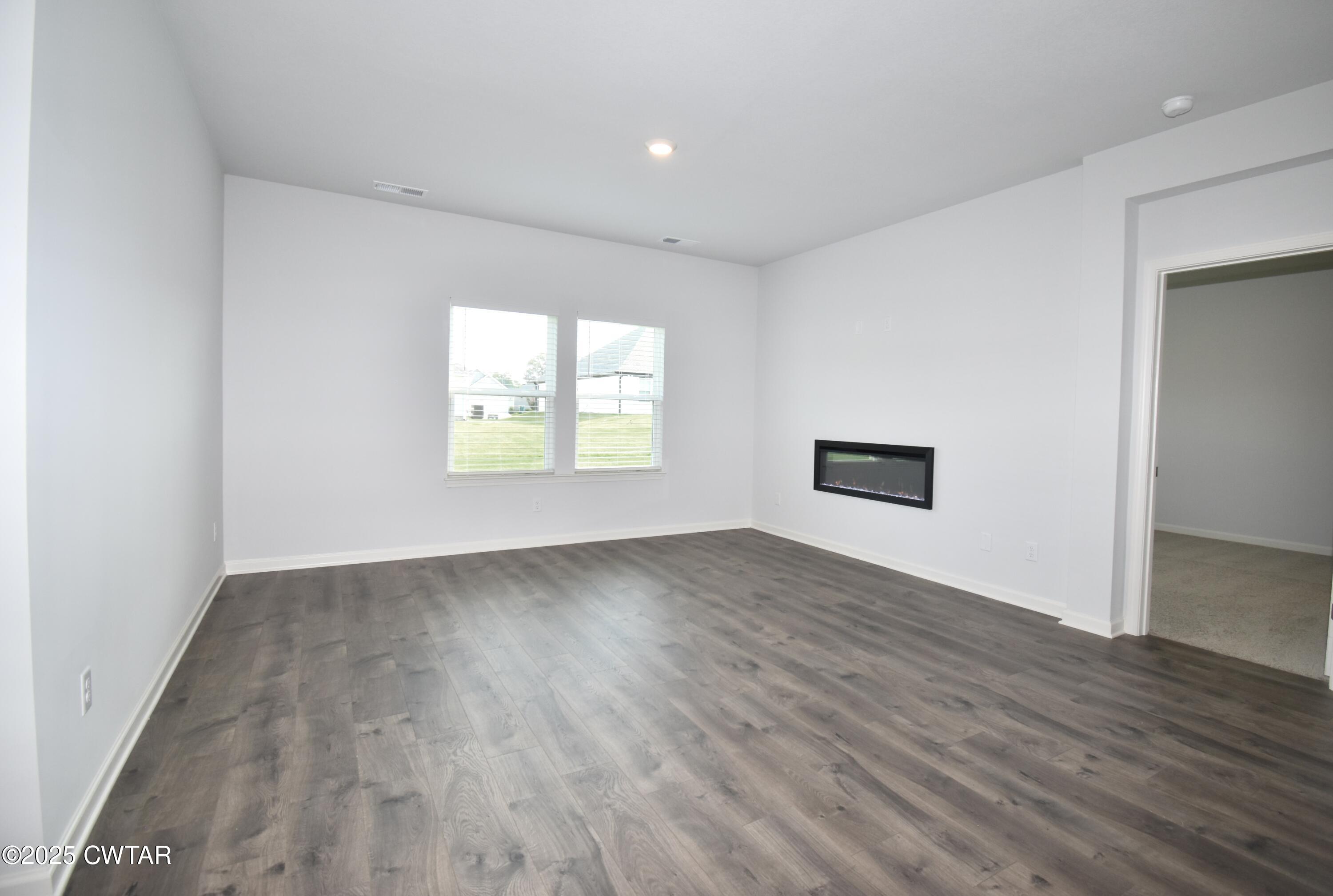 75 Clarendon Cove Jackson, TN 38305 - Photo 5 of 21 an empty room with wooden floor and a window