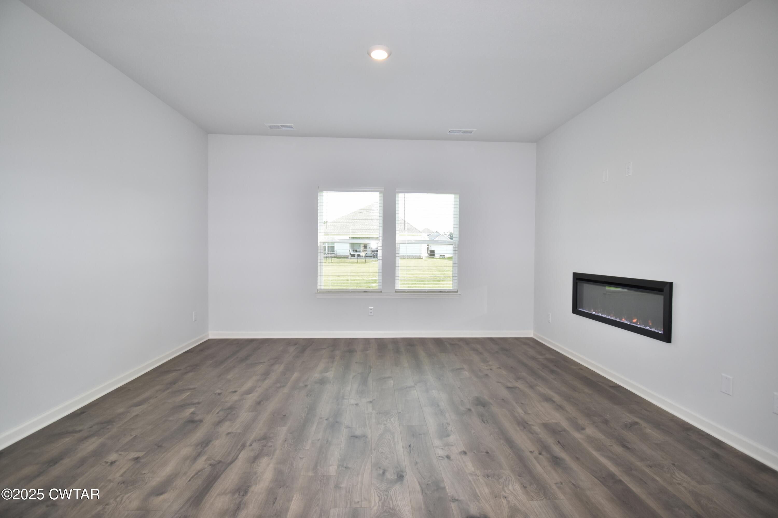 75 Clarendon Cove Jackson, TN 38305 - Photo 7 of 21 an empty room with wooden floor and windows