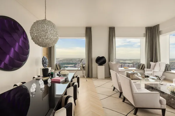 a living room with furniture a chandelier a large window and a table