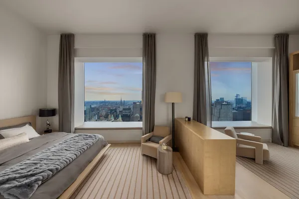 a bedroom with a bed and a large window