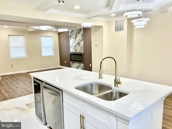 a close view of a sink and dishwasher with kitchen island