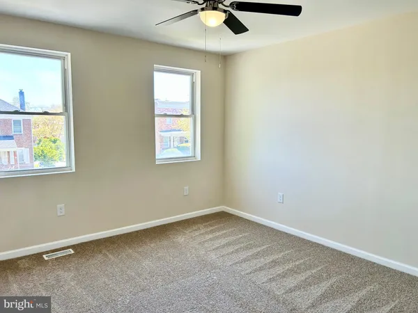 an empty room with a window and a fan