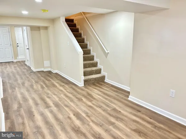 a view of a livingroom with wooden floor and stairs