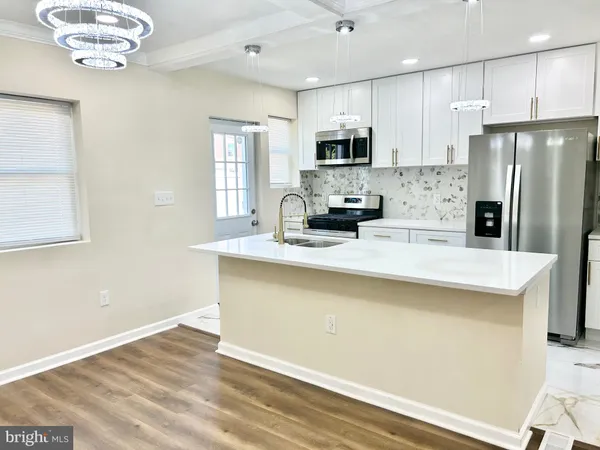a kitchen with stainless steel appliances a refrigerator sink and microwave