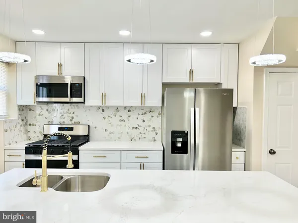 a kitchen with stainless steel appliances a refrigerator sink and microwave