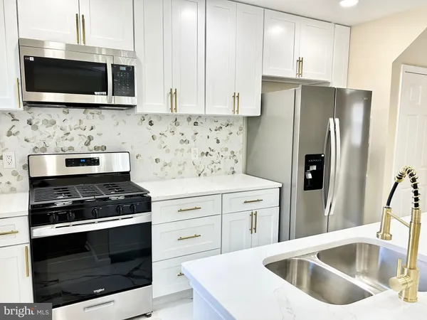 a kitchen with stainless steel appliances a stove microwave and refrigerator