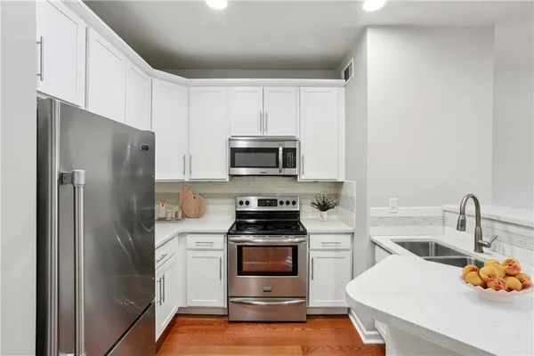 a kitchen with a refrigerator and a stove top oven