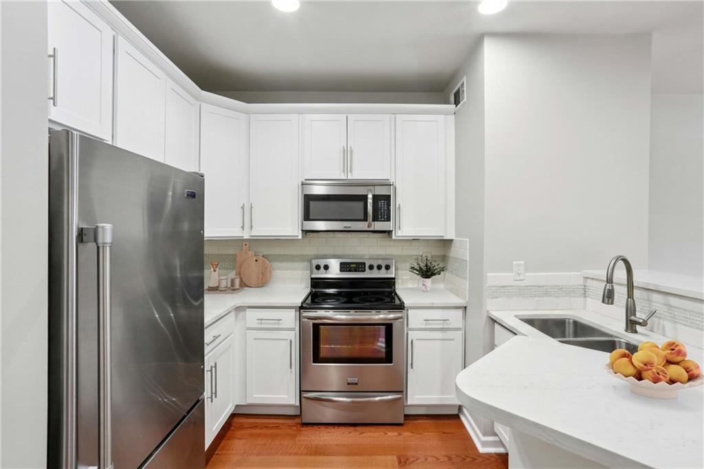 a kitchen with a refrigerator and a stove top oven